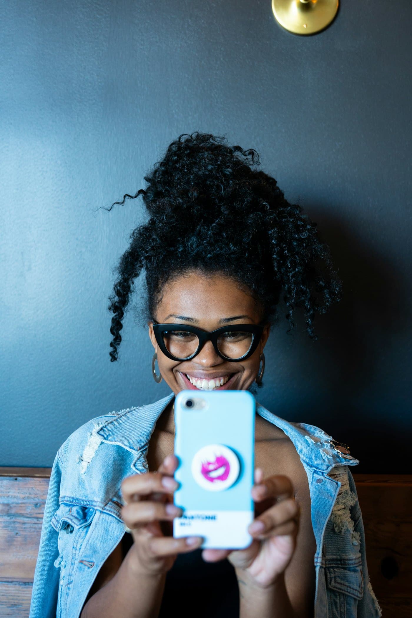 A woman smiling at her phone