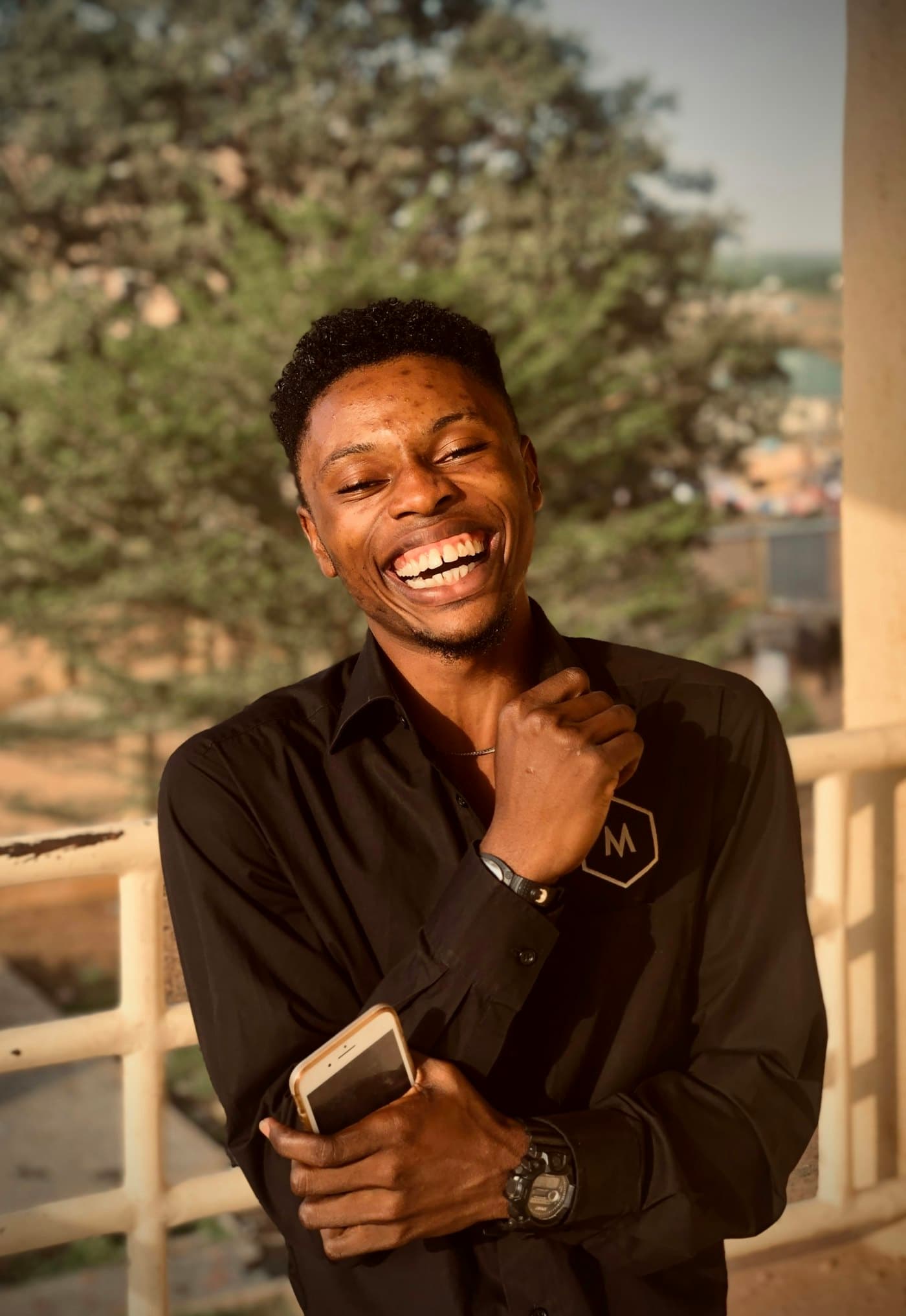 A man laughing, holding his phone